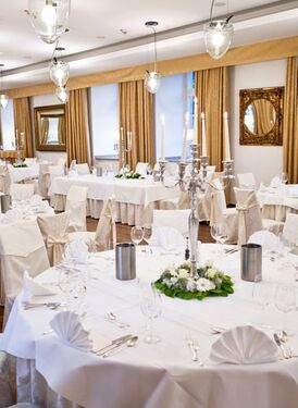 Großer Saal mit in weiß gedeckten Tischen